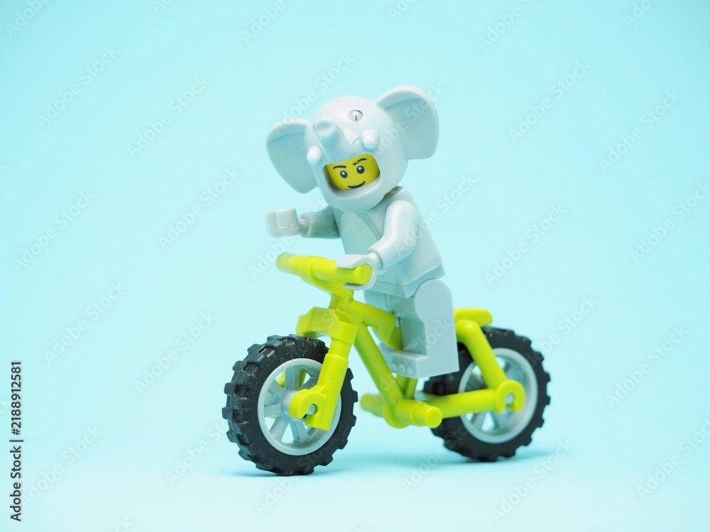 Obraz premium Indonesia - October 3, 2023 : Mini toy of action figure at table with blurred background. Toy photography concept. Riding the bicycle conceptual design.