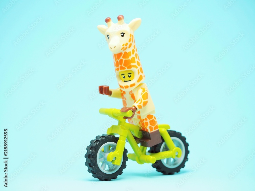 Fototapeta premium Indonesia - October 3, 2023 : Mini toy of action figure at table with blurred background. Toy photography concept. Riding the bicycle conceptual design.