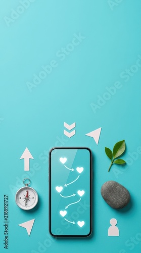 Minimalist mental health wellness navigation flatlay with smartphone showing heart waypoints, compass, stone, and leaf on turquoise background with copy space.