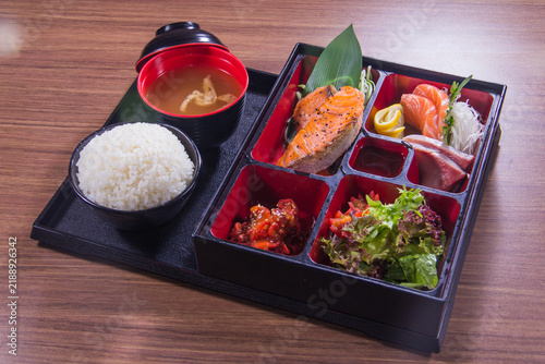 Delicious bento box meal with salmon, rice, and vegetables served in a traditional style