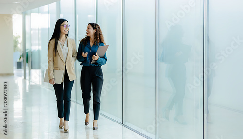 Asian and Middle Eastern Businesswomen Walking in Office Corridor