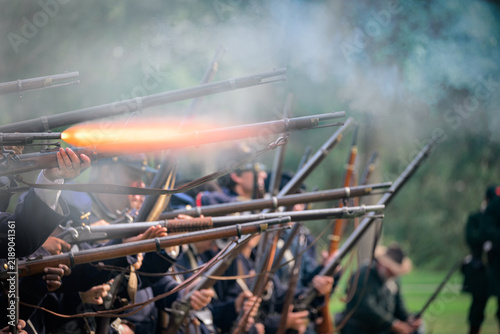 Quadro su tela Civil War reenactors portraying Union infantry fire a coordinated volley with ri