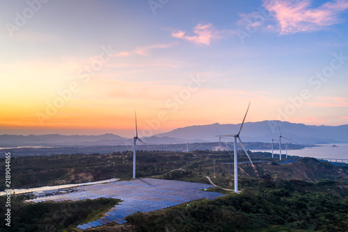 Quadro su tela wind turbines and solar panels in mountains at dusk