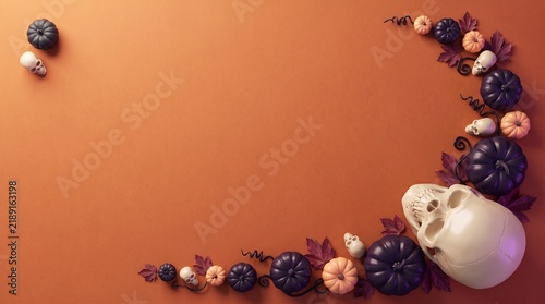 A human skull surrounded by decorative small pumpkins and dark berries arranged on a plain warm orange background surface view