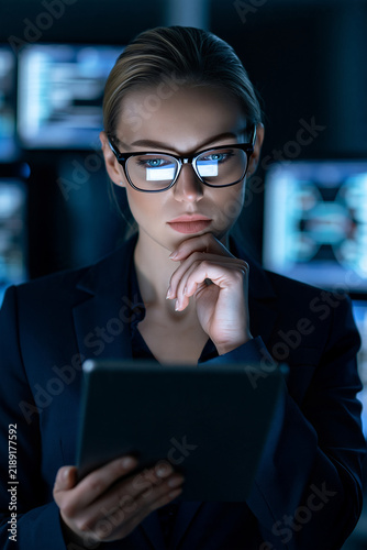 female manager analyzing AI agent recommendations on tablet in modern office, realistic corporate stock photo