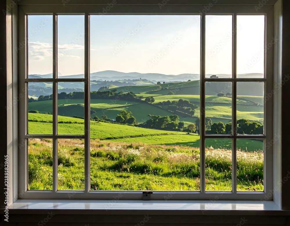 Obraz premium A serene view of a lush green countryside and rolling hills framed by a classic white window. Ideal for travel, nature, and interior design concepts.
