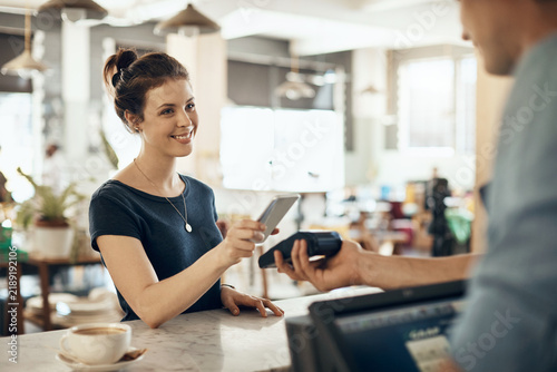 Phone  smile and payment with woman in cafe for fintech  pos machine and barista checkout. Customer experience  mobile transaction and digital banking with people in coffee shop for app and sale