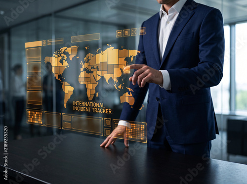 International incident tracker displayed on golden holographic projection used by corporate executive pointing at map for global business risk management.