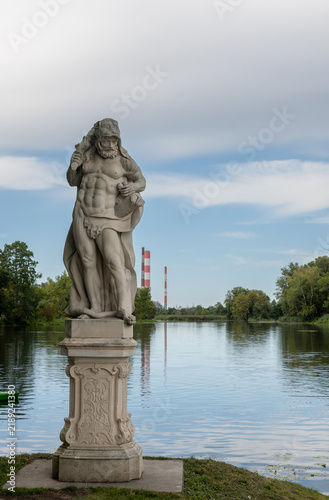 Statue of demigod Hercules next to a small pond at Wilanow palace in Warsaw city-Poland.