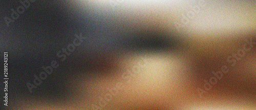 Blurred artistic surface showing a warm gradient blend of dark charcoal and glowing golden amber tones