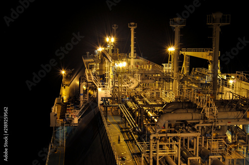 Foto Industrial piping and equipment on a gas carrier deck at night