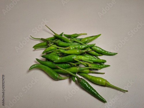 Canvas Print Fresh green chili peppers arranged in a pile on a clean, neutral background with copy space