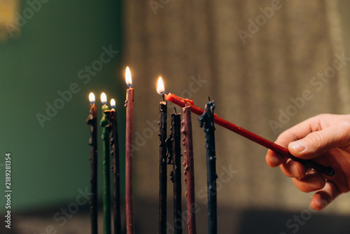 Hand lighting hanukkah candles celebrating jewish festival of lights