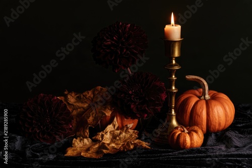 Gothic Halloween still life with candle and pumpkins