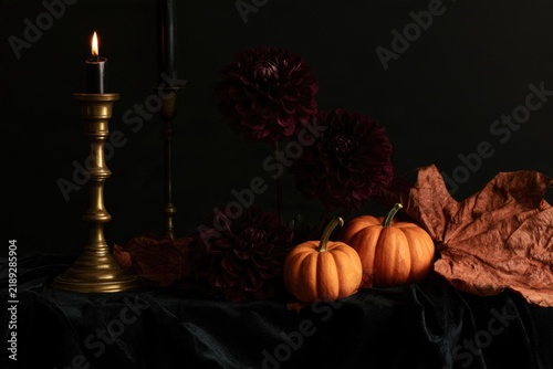 Gothic Halloween still life with candle and pumpkins