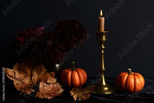 Gothic Halloween still life with candle and pumpkins