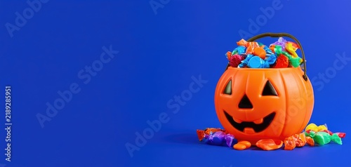 Halloween pumpkin candy bucket on blue background