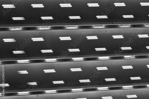 Foto The inside of a roller shutter that isn't fully lowered, with daylight streaming through the open slits in the slats onto the back