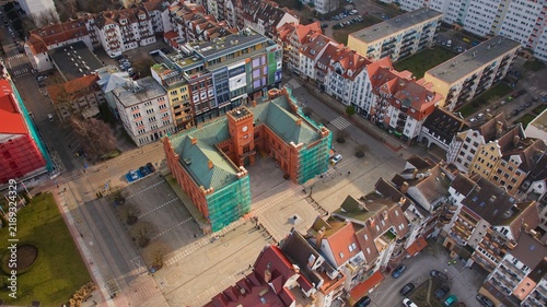 Kołobrzeg’s city center from above, featuring the Town Hall under renovation, and the vibrant market square at sunrise.