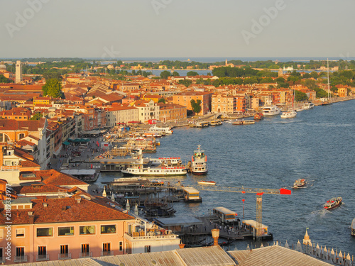 Aerial view of Venice waterfront showing historic buildings, boats, and Grand canal at golden hour