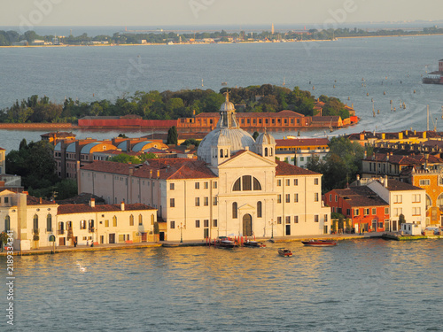 Aerial view of Venice waterfront featuring white domed church and colorful buildings along canal