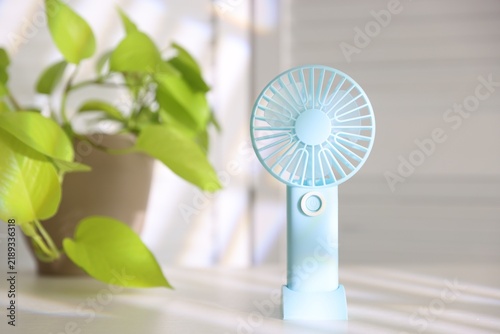 Mini fan on white table indoors, closeup. Space for text