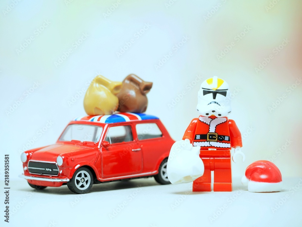 Fototapeta premium Indonesia - September 11, 2023 : Mini toy at table with blurred background. Santa Claus carrying gift concept design.