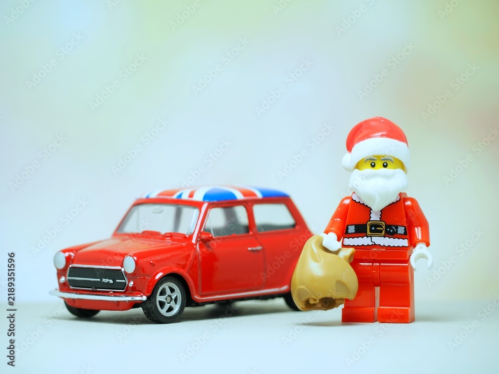 Fototapeta premium Indonesia - September 11, 2023 : Mini toy at table with blurred background. Oldman Santa Claus carrying gift concept design.