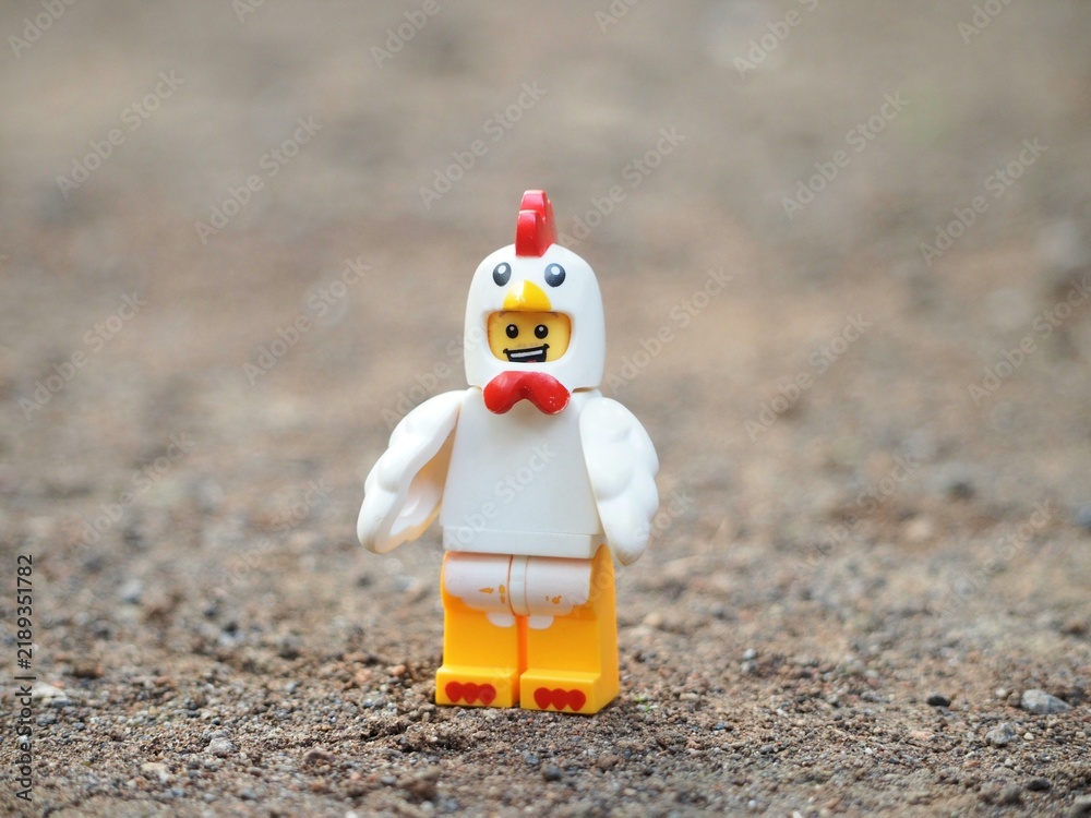 Obraz premium Indonesia - November 23, 2024 : Mini toy of action figure at outdoor with blurred background. Miniature photography concept design. Minifigure of chicken character at rock.