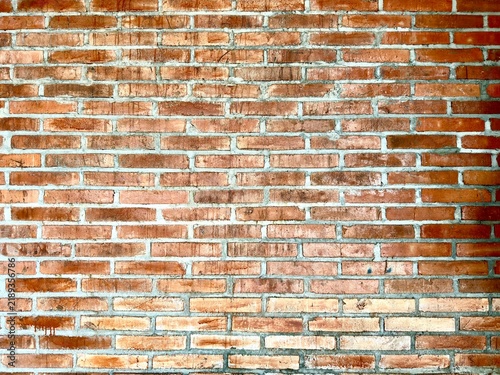Rough orange brick wall background texture, exposed masonry surface with rustic pattern
