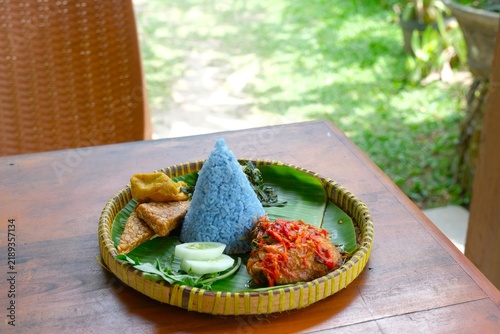 Fotografie Nasi Biru Ayam Kemangi or Blue rice served with spicy basil chicken, raw vegetab