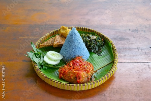 Canvas Print Nasi Biru Ayam Kemangi or Blue rice served with spicy basil chicken, raw vegetab