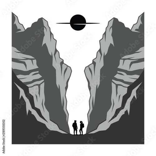 Two silhouetted people standing at edge of deep canyon with sun