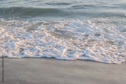 фотографія Gentle Ocean Waves Washing Over Sandy Beach Shore