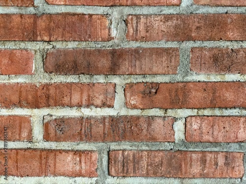 Close up rough orange brick wall texture, zoomed exposed masonry surface with rustic pattern