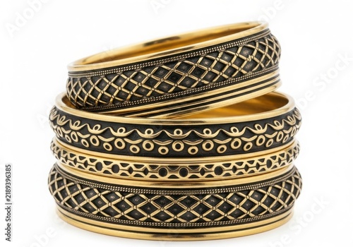 Stacked intricately designed bracelets with gold and green accents isolated on white background