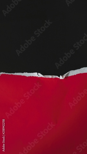 Abstract background with a torn red paper edge over a black surface.