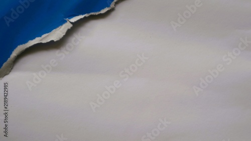 Abstract background with a torn blue paper edge revealing a white surface.