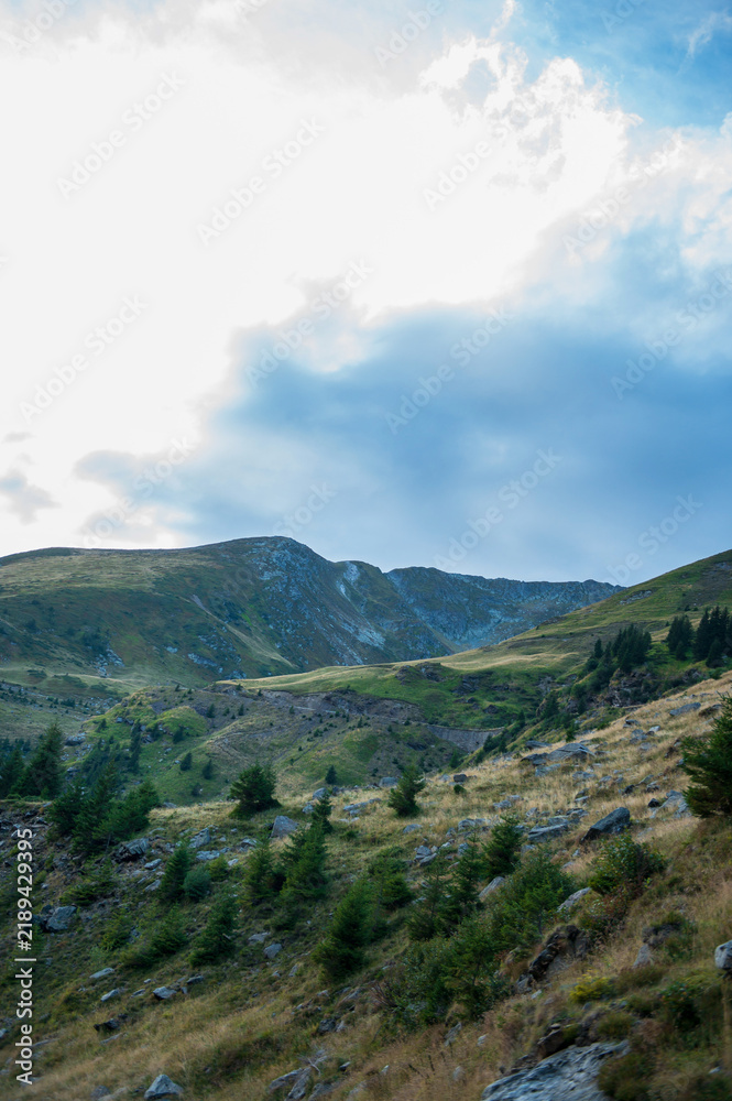 Fototapeta premium Dramatic mountain landscape with a bright blue sky and clouds in the Carpathian Mountains, Romania