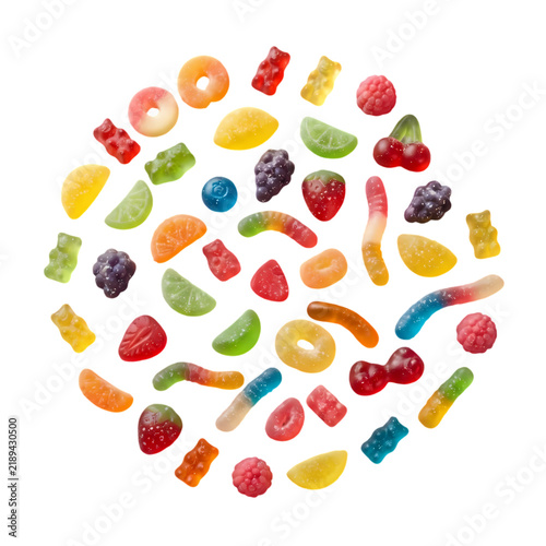 Assorted colorful fruit jelly candies arranged in a circular pattern on white background