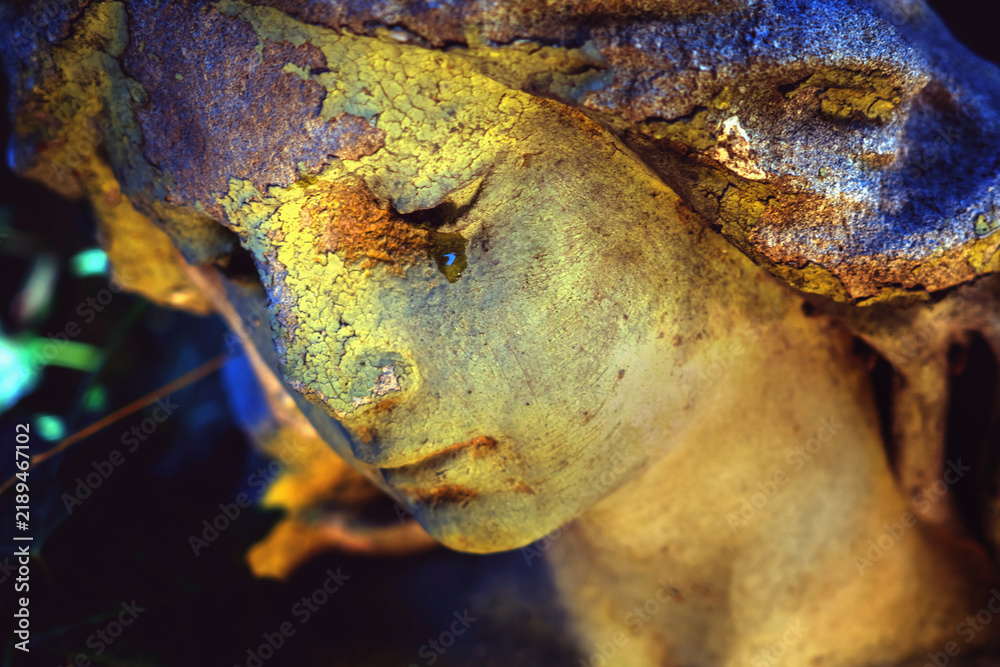 Fototapeta premium Close-up of an ancient weathered angel statue with a peaceful face, symbolic image of memory, grief, eternity and the passage of time.