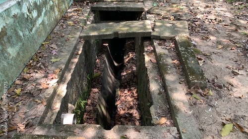 Foto Open concrete drainage channel containing dried leaves and debris, designed for