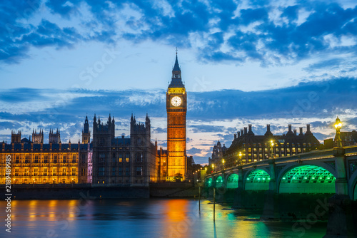 Night view of the Houses of Parliament and Big Ben along the Thames River in London, England.