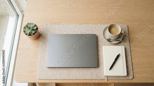 Obraz na płótnie Minimalist Professional Workspace with Closed Laptop Coffee Cup and Notebook on Light Wooden Desk