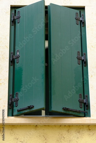 A house window with partially closed wooden shutters, Italy, Verona