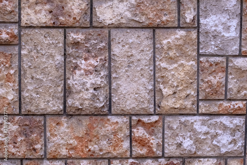 Quadro su tela Close up view showing a rugged natural stone wall facade, featuring various shap
