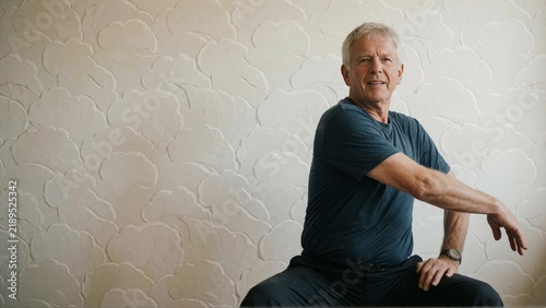 Senior Man Stretching Indoors Portrait.