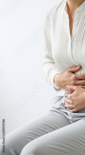 Woman holding her stomach in discomfort, symbolizing pain or internal distress, suitable for medical or health-related concepts