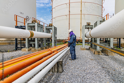 Male worker inspection at steel long pipes and pipe elbow in station oil factory during refinery valve of visual check record pipeline
