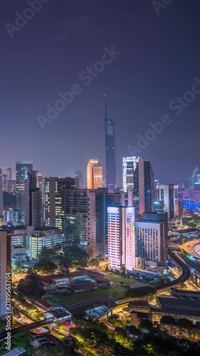 Vertical Time lapse footage of Kuala Lumpur city center at blue hour, featuring modern skyscrapers, illuminated buildings, busy roads, and a vibrant urban skyline in Malaysia.